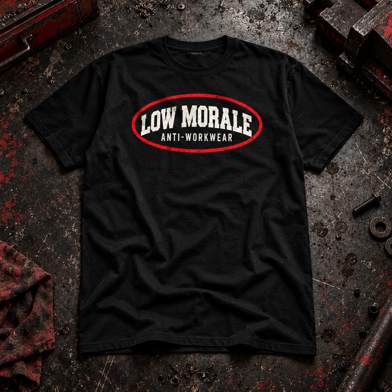 Black LOW MORALE Circle Tee on a worn industrial workshop surface
